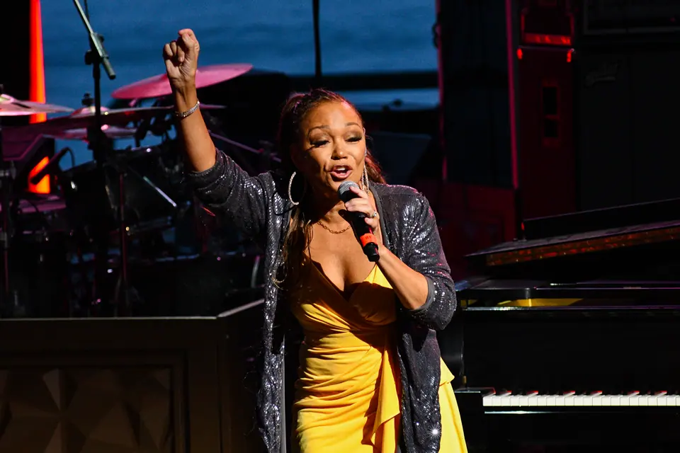 Chanté Moore raises a fist mid-performance