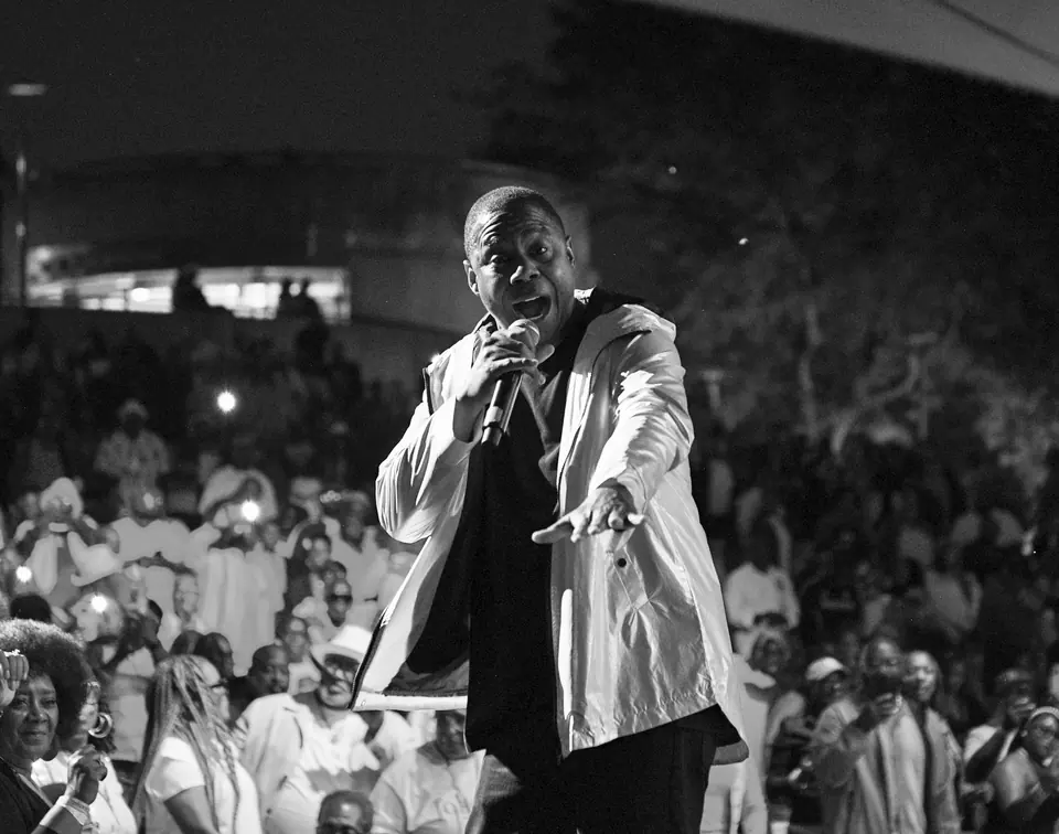 A performer reaches toward a packed amphitheatre crowd at J3 Productions' 2026 Father's Day show in Detroit