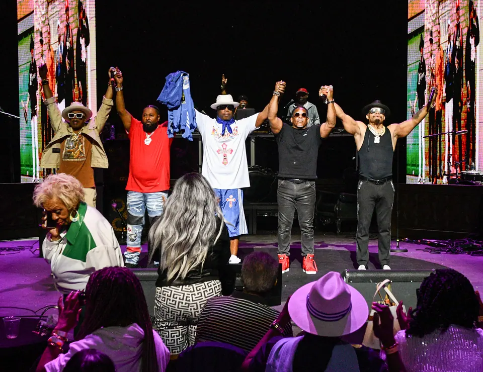 Performers join hands for a bow in front of LED walls while the front rows stand